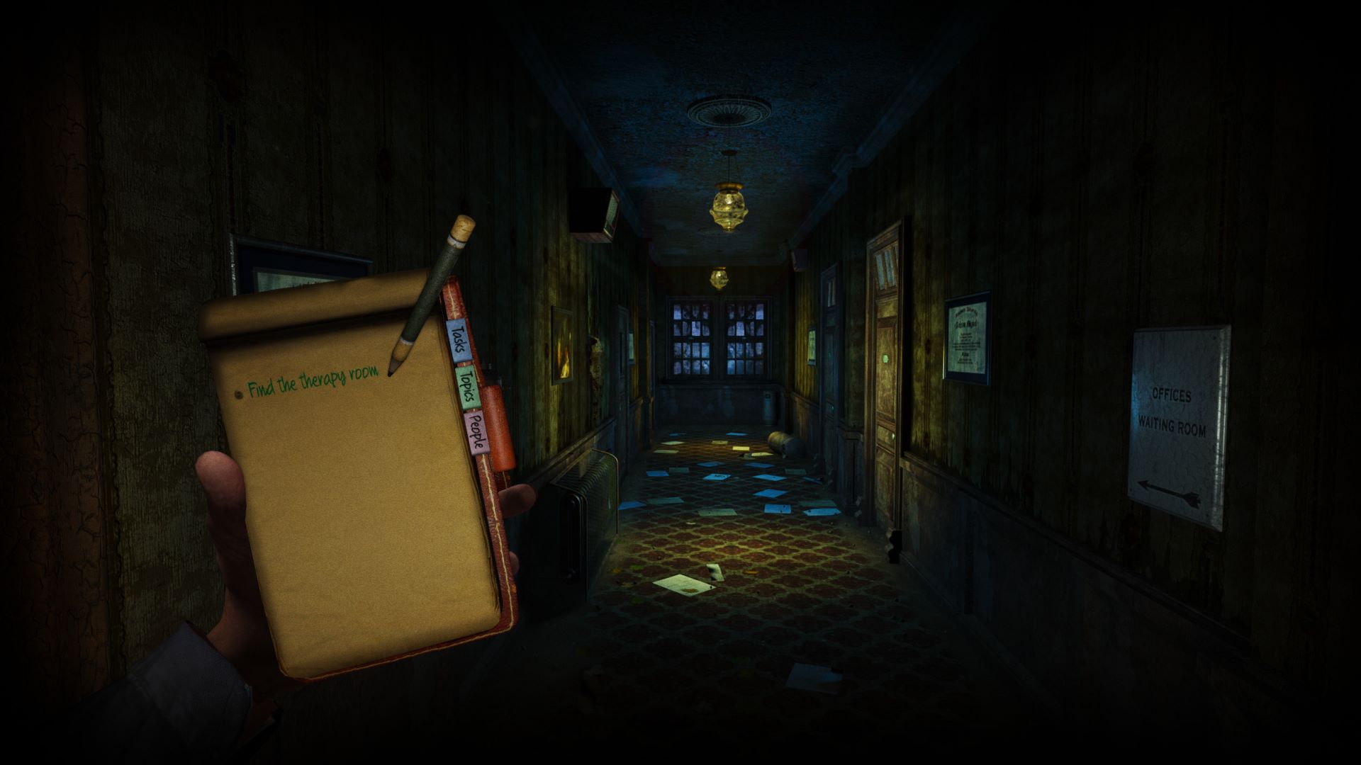 First-person screenshot from ASYLUM, showing the protagonist's hand holding up a notebook while walking through a dark corridor.