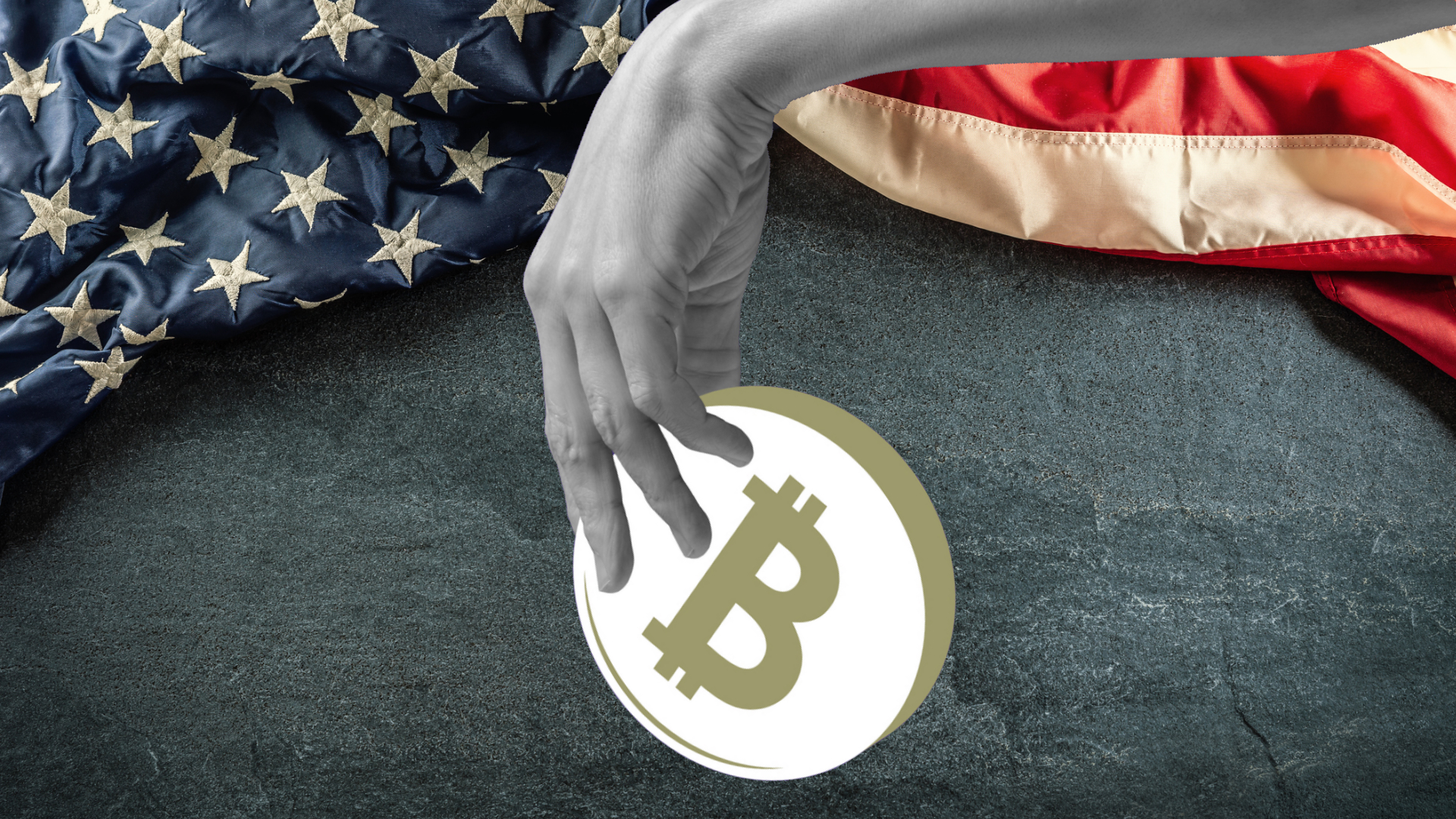 bz3bdfbsstxsb7gtfgdoau-1 A hand holds a bitcoin over the US flag draped over a slate board.