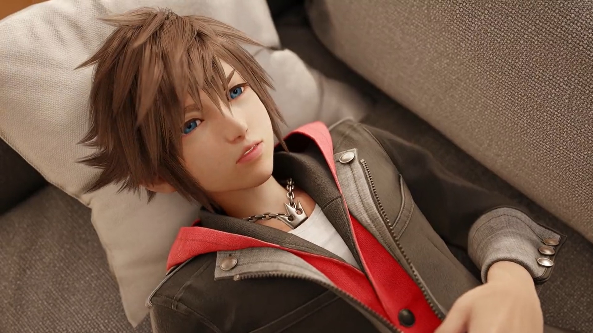 A screenshot from the Kingdom Hearts 4 announcement video showing Sora lying on a grey couch.