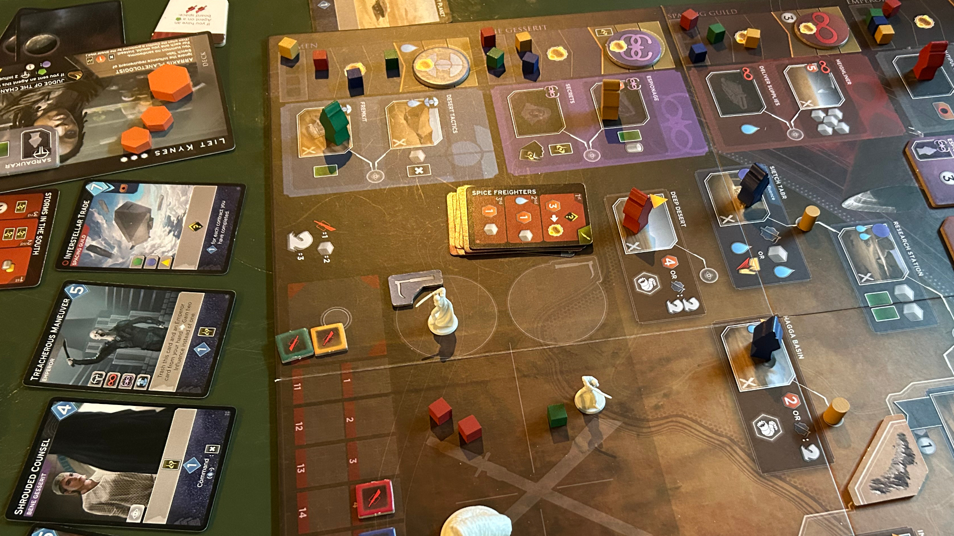 Dune: Imperium - Bloodlines board, tokens, and cards set up on a green surface