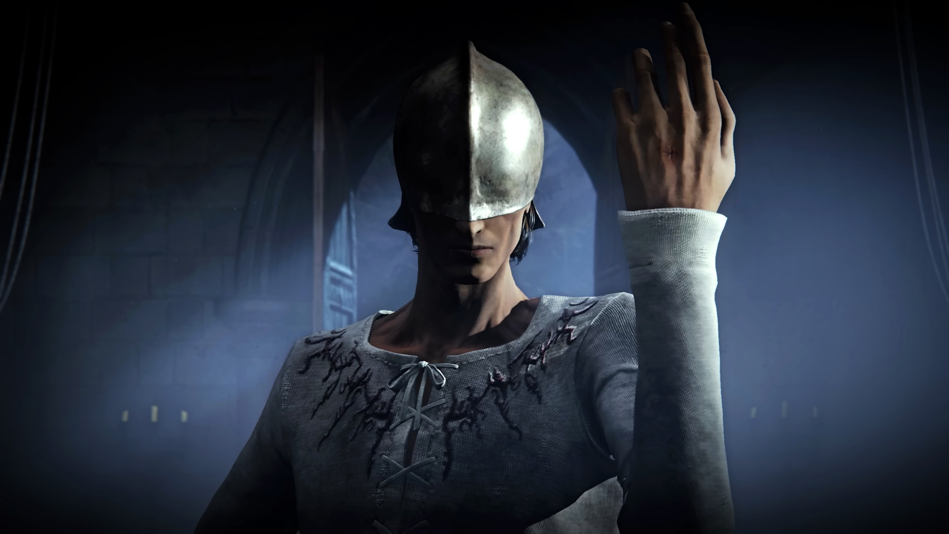 A person seen with a helmet over their eyes and one hand raised into the air in The Duskbloods trailer