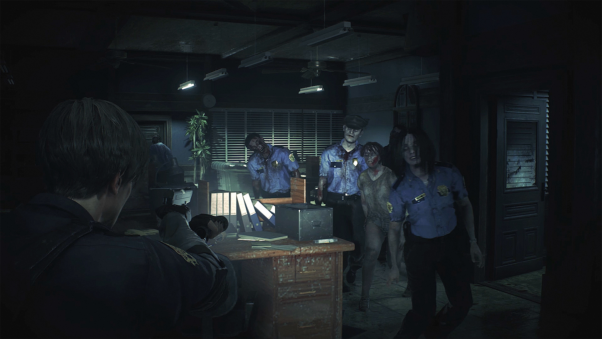 Resident Evil 2 Remake screenshot of Leon fighting four zombies in the Raccoon City Police Department offices.