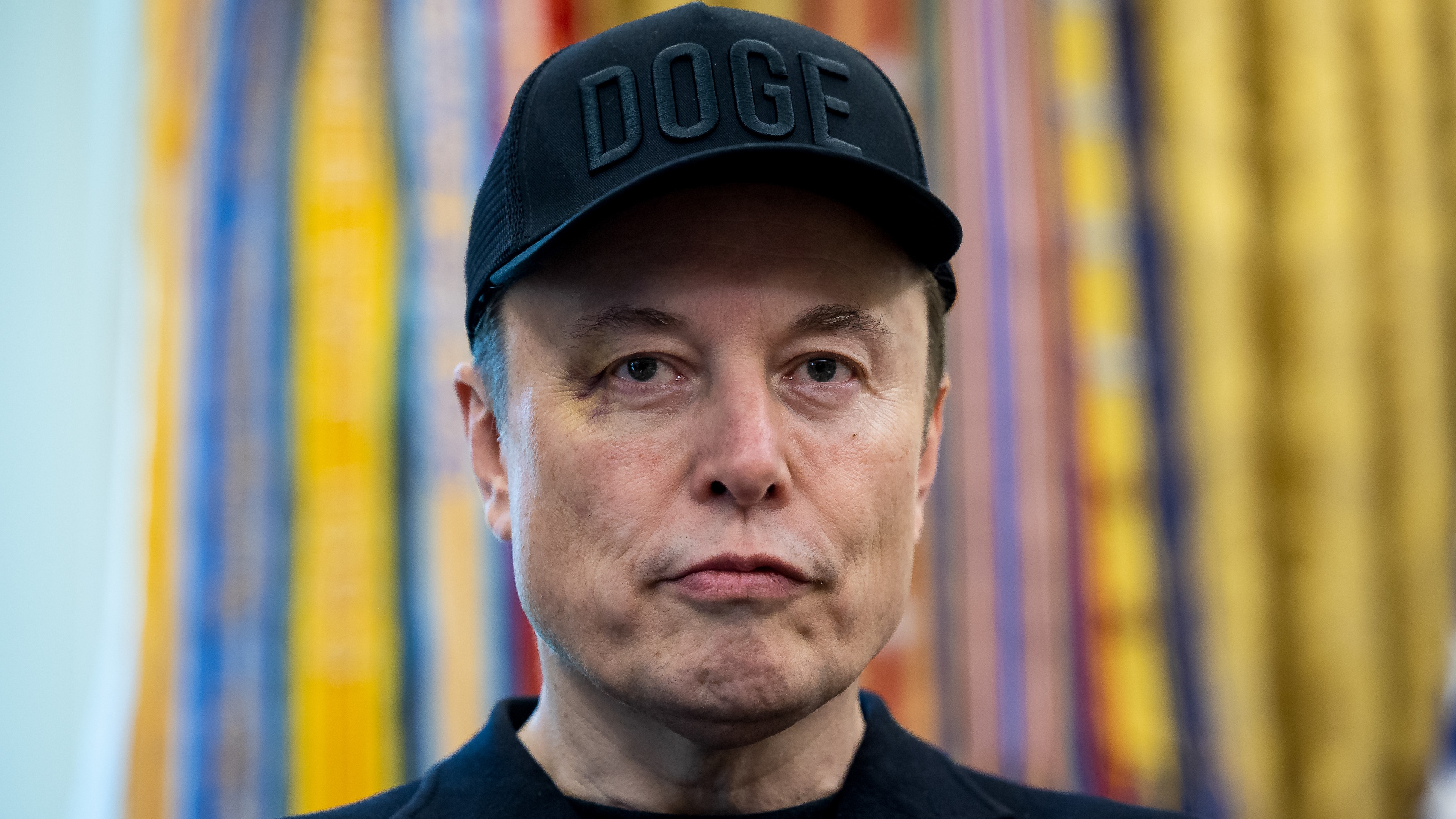 Elon Musk, chief executive officer of Tesla Inc., wears a &quot;DOGE&quot; hat during a news conference in the Oval Office of the White House in Washington, DC, US, on Friday, May 30, 2025. The event gives an opportunity for the president and his largest campaign benefactor to dispel any notion of an acrimonious divorce. Photographer: Francis Chung/Politico/Bloomberg via Getty Images