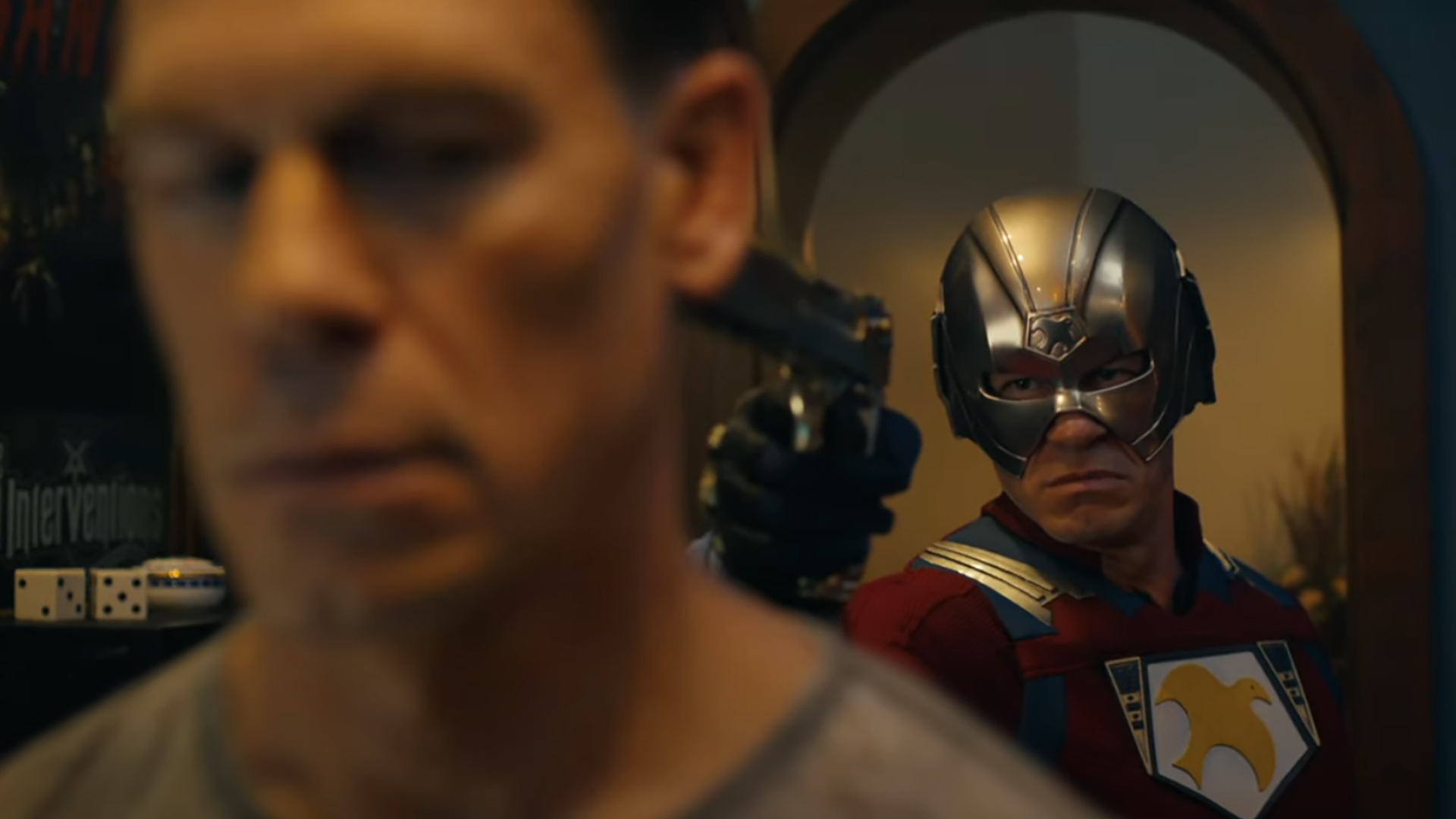 John Cena as Peacemaker holds a gun to the head of a different John Cena as Peacemaker in Peacemaker season 2.