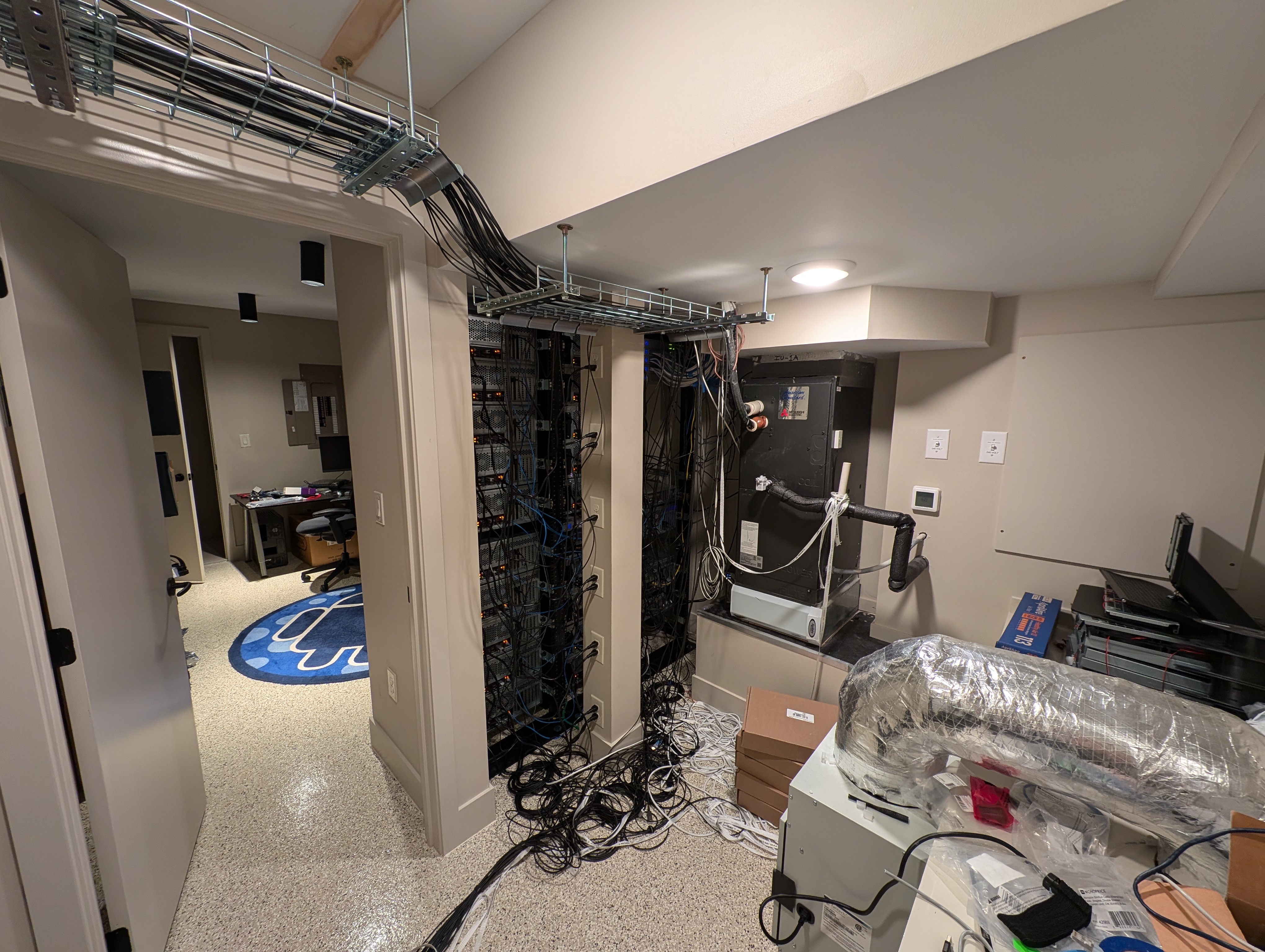 zyckn9bvdogaaczxvwssm3 The 'hot side' of the LAN party house's server room. Wires and fans can be seen all around--this space is definitely not intended for guests to regularly access.